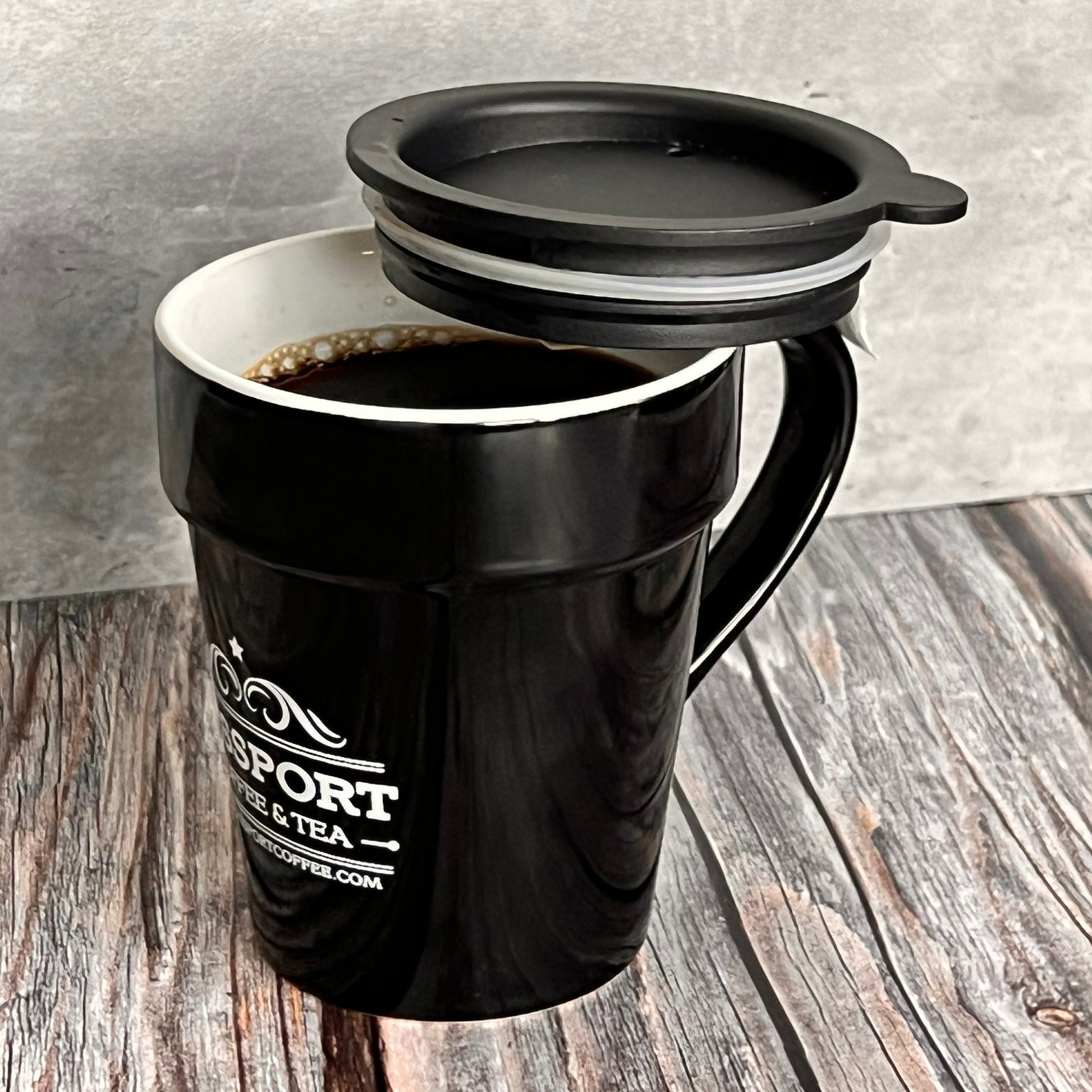 Black Passport Ceramic Travel Mug with silicone lid and double-walled insulation, 11oz capacity.