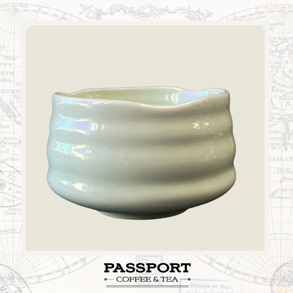 A light green ceramic tea bowl with a scalloped rim and horizontal ridges for Matcha Tea